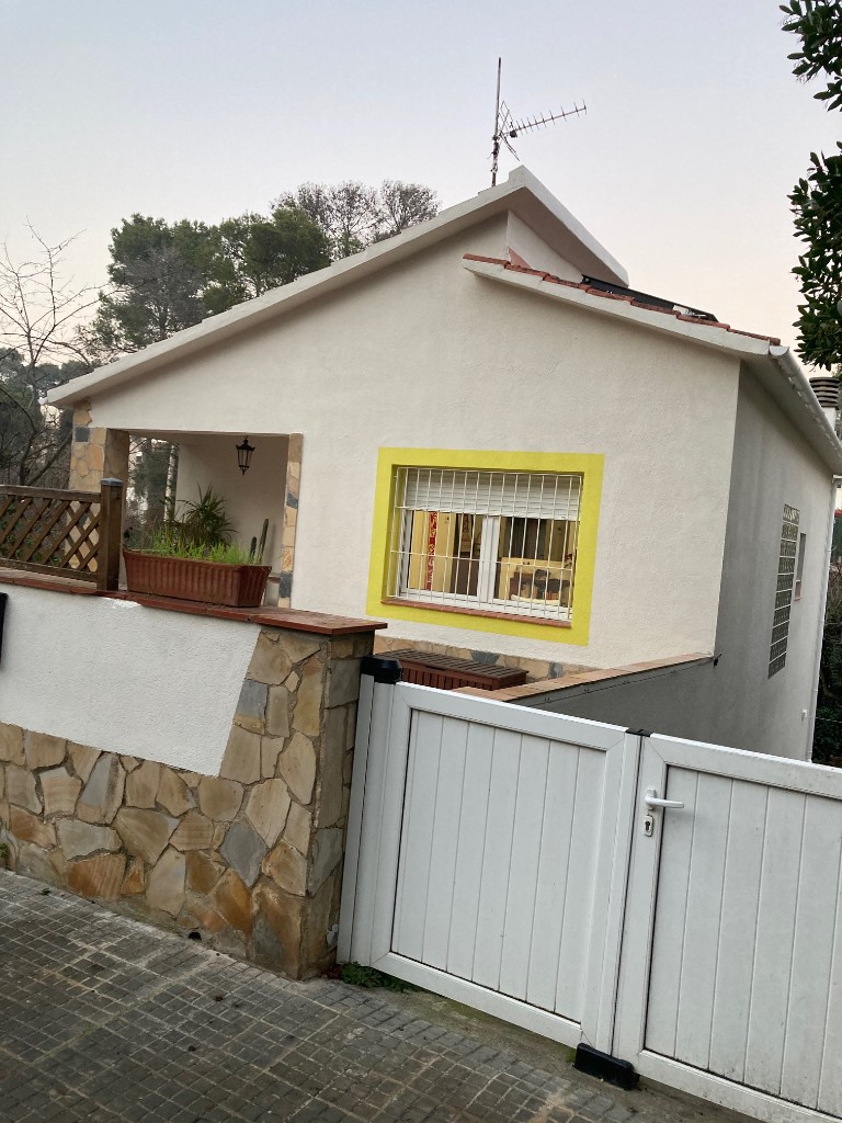 Reforma exterior con verja blanca, zócalo de piedra y acceso peatonal, La Floresta