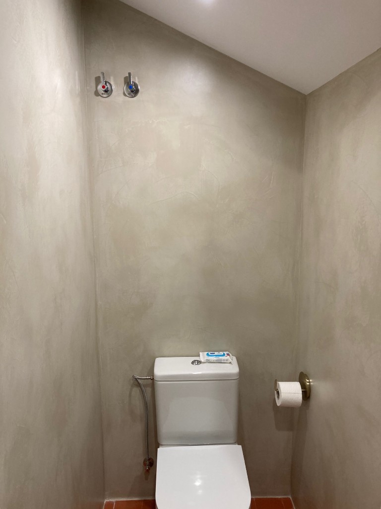 Lateral de vivienda con porche revestido en piedra natural y carpintería exterior, La Floresta