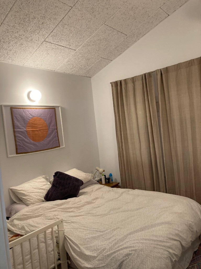 Dormitorio reformado con cama cabecero textil iluminación indirecta y cortinas, La Floresta